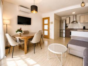a dining room and living room with a table and chairs at Casa 3 hab, piscina, playa, parking, L'Ampolla in L'Ampolla