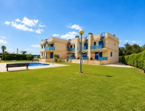 a large building with a lawn in front of it at Casa 3 hab, piscina, playa, parking, L'Ampolla in L'Ampolla