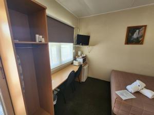 a room with a bed and a desk and a window at Murrurundi Motel - CITY CENTRE in Murrurundi