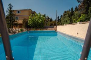 a swimming pool with blue tiles on the side of a building at Villa Vasiliki in Lefkimmi