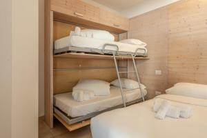 a room with two beds and white pillows at Molveno Garden Suite in Molveno