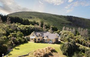 an aerial view of a house on a green hill at Peninsula Paradise in Dunedin