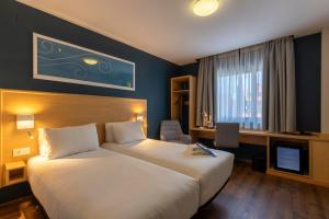 a hotel room with a bed and a television at Travelodge Madrid Arturo Soria in Madrid