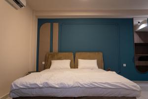 a bed in a room with a blue wall at Dremka Guesthouse Peshtani in Ohrid