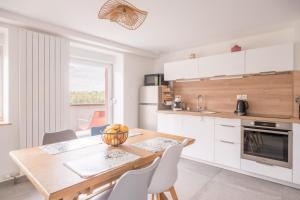 a kitchen and dining room with a wooden table and chairs at Chez Mémé in Engenthal +14 photos