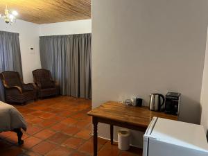a room with a kitchen with a table and a refrigerator at The Old Posthouse in Ladismith
