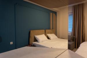 a bedroom with two beds and a blue wall at Dremka Guesthouse Peshtani in Ohrid