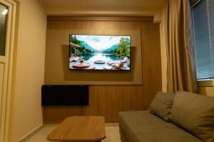 a living room with a flat screen tv on a wall at Dremka Guesthouse Peshtani in Ohrid