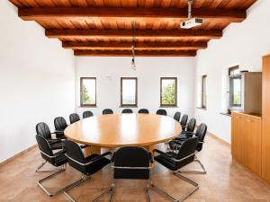 a conference room with a wooden table and black chairs at HOSTEL VANEČA in Puconci