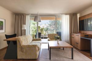 a living room with a couch and a table at Hotel Mignon Meran Park & Spa in Merano