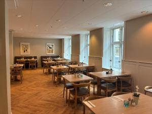 a restaurant with wooden tables and chairs and windows at City Hotel Nebo in Copenhagen
