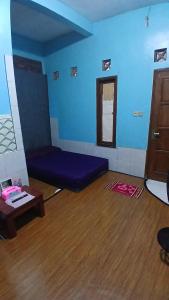 a blue room with a couch and a table at NN Kost 009 Manage by Omm Kost in Beran-kidul