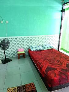 a bedroom with a red bed and a fan at NN Kost 009 Manage by Omm Kost in Beran-kidul
