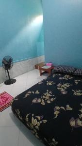 a bedroom with a bed with a black blanket with flowers at NN Kost 009 Manage by Omm Kost in Beran-kidul