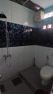 a bathroom with a toilet and a shower at NN Kost 009 Manage by Omm Kost in Beran-kidul