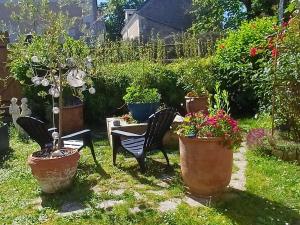a garden with a table and chairs and potted plants at L'intervalle des 18 châteaux in Saint-Georges-sur-Cher