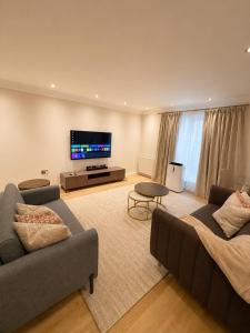 a living room with two couches and a flat screen tv at Spacious 3BR Lancaster Gate Near Hyde Park in London