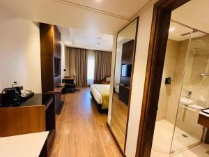 a hotel room with a bed and a bathroom at Regenta Place Jhansi by Royal Orchid Hotels Limited in Jhānsi +22 photos
