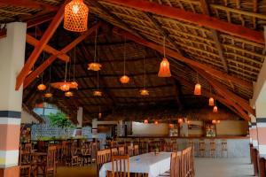 a dining room with tables and chairs and chandeliers at Marionel Hôtel in Ampilahoa