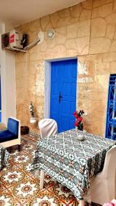 a room with a blue door and a table and chairs at Dar Aziz VIP in Sousse +46 photos