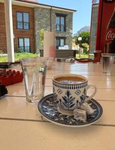 a cup of coffee on a plate on a table at Bergüzar Hanım Konukevi in Gokceada Town