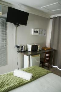 a room with a kitchen with a microwave and a table at Gemutlich Guesthouse in Upington