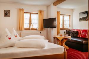 a hotel room with two beds and a couch at Gästehaus Walserheimat in Riezlern