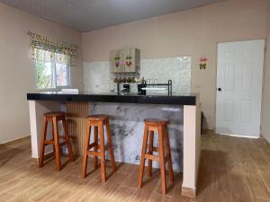 a kitchen with a counter with three bar stools at California, Volcán, casa completa in Nueva California