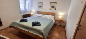 a bedroom with a bed with two black hats on it at ISTRIEN-ADRIA in Rabac