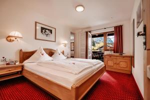 a bedroom with a large bed and a red carpet at Gästehaus Walserheimat in Riezlern
