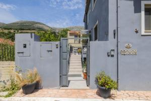 a white building with stairs and plants in front of it at Villa Kirki Apartments in Agia Effimia