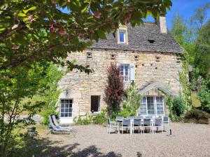 a building with tables and chairs in front of it at Domaine de Bagnegrole in Saint-Cyprien