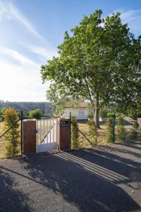 an open gate with a fence and a tree at Los Sauces By Silastur in Villaviciosa