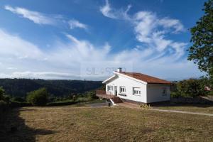 a small white house with a staircase in a field at Los Sauces By Silastur in Villaviciosa