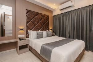 a hotel room with a large bed and a mirror at Hotel Zillion International Near US Consulate B K C Mumbai Near Mumbai Airport Mumbai in Mumbai