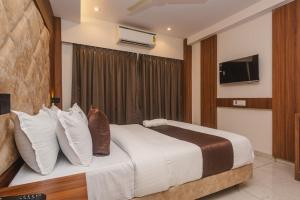 a bedroom with a large bed with a tv on the wall at Hotel Zillion International Near US Consulate B K C Mumbai Near Mumbai Airport Mumbai in Mumbai