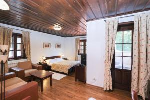 a bedroom with a bed and a living room at Hotel Ivanov Konak i Depadans Palac in Cetinje