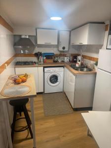a small kitchen with white appliances and a table at Pátio de Alfama in Lisbon +5 photos