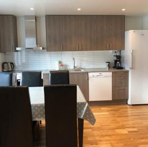 a kitchen with a table and a white refrigerator at ROOMS by Kåkern Bridge in Sund +3 photos