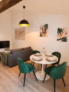 a living room with a table and chairs and a couch at Escapade cosy - Sauternes & Château à pied in Villandraut