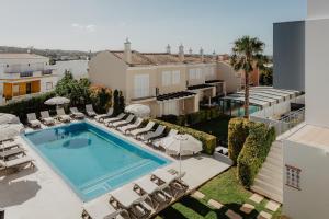 an aerial view of a pool with chairs and a building at Hotel Sao Sebastiao de Boliqueime in Boliqueime