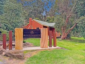 a sign in front of a building with a house at Ironbark Villa 2 in Halls Gap