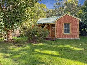 a brick house in a yard with a tree at Ironbark Villa 2 in Halls Gap