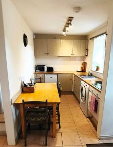 a kitchen with a wooden table and a sink and a stove at Mews Cottage in Middleton in Teesdale