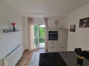 a living room with a kitchen with a stove and a tv at FeWo Carolina in Püttlingen