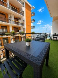 a black table on the balcony of a building at Harbor Elegance Estate in Milazzo