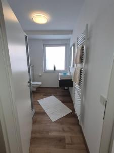 a hallway with a bathroom with a sink and a toilet at FeWo Carolina in Püttlingen