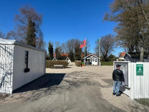 a man is standing in front of a gate at Stege Camping in Stege