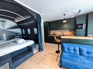 a bedroom with a bed and a blue couch at Airliner Apartment First Class Stay in Cluj-Napoca
