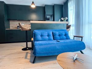 a living room with a blue couch and a table at Airliner Apartment First Class Stay in Cluj-Napoca